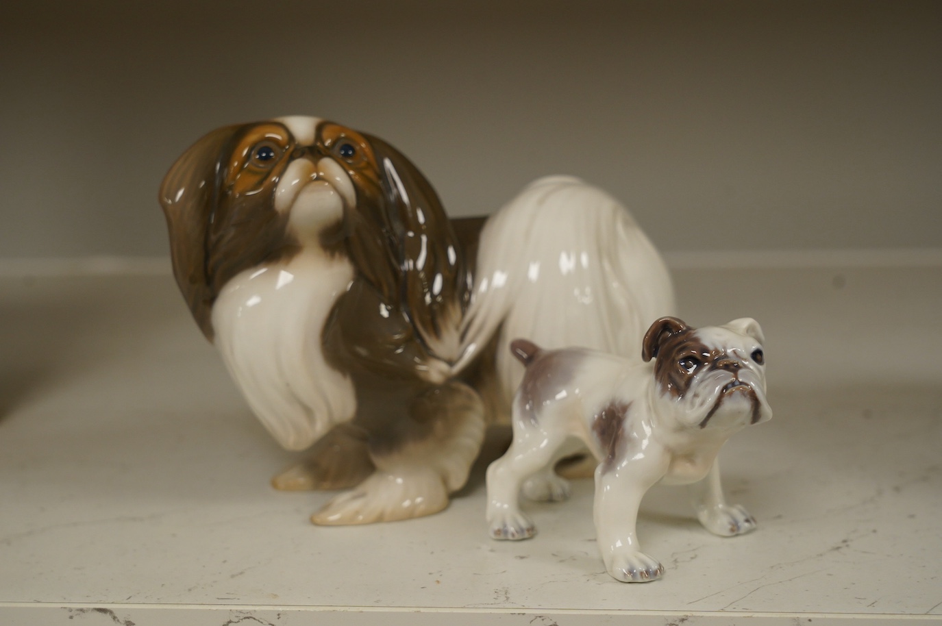 An early Bing & Grondahl figure of a Japanese Chin 12cm high, and a Dahl Jensen small bulldog, 7cm high. Condition - good